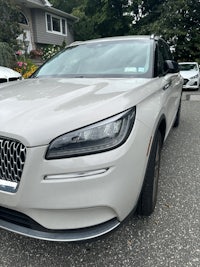 the front end of a silver car parked in a driveway